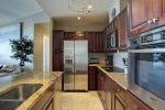 Kitchen features high end appliances, separate cooktop and stove, and breakfast bar. 